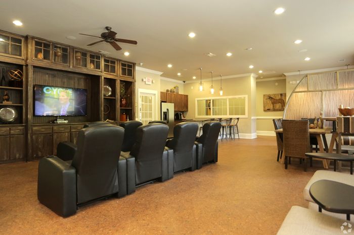Luxurious living space with cozy leather seating, a large TV, stylish bar area, and elegant dining setup, perfect for entertaining.