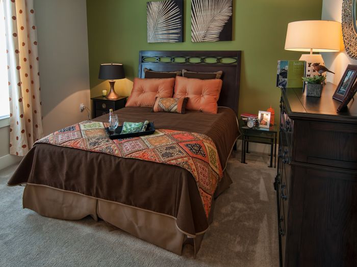 Cozy bedroom with elegant decor, featuring a plush bed framed by stylish lamps and modern furnishings, creating a warm and inviting atmosphere.