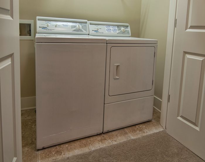 Convenient in-unit laundry area featuring a washer and dryer on stylish tiled flooring, enhancing modern apartment living.