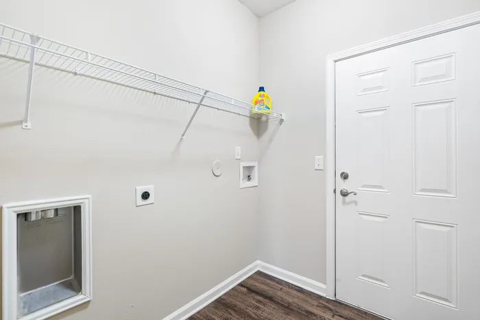 Modern laundry room with sleek shelving and bright lighting, perfect for efficient use.