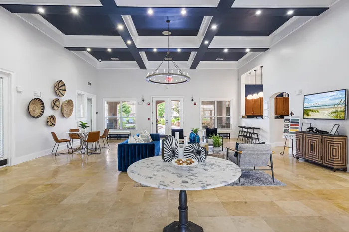 Elegant apartment lounge with high ceilings, chic lighting, modern decor, and ample natural light.