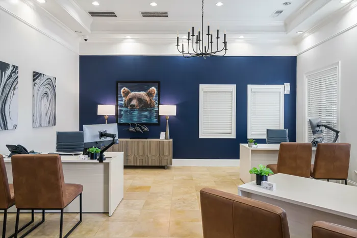 Elegant office space featuring sleek desks, leather chairs, and bold blue accent wall with unique bear artwork.