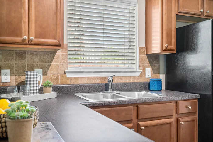 Charming kitchen with modern fixtures, elegant wooden cabinets, and a bright window view.