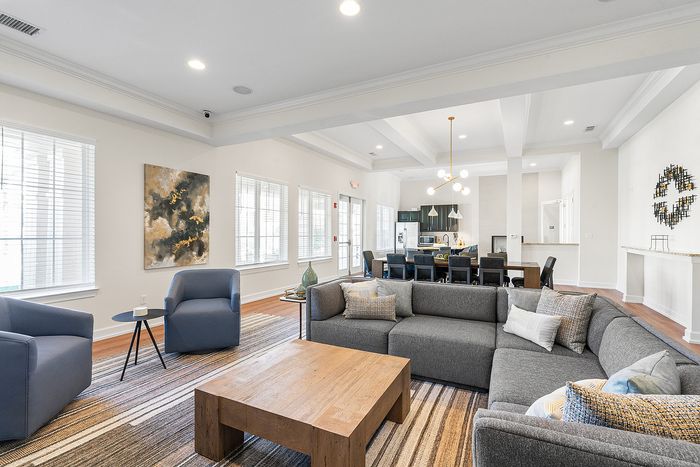 Modern open-plan living area featuring a cozy sectional sofa and stylish dining space with elegant lighting.
