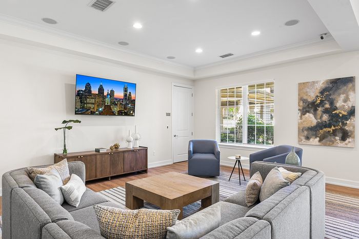 Chic living room with stylish grey sectional sofa, modern decor, and large window offering natural light.