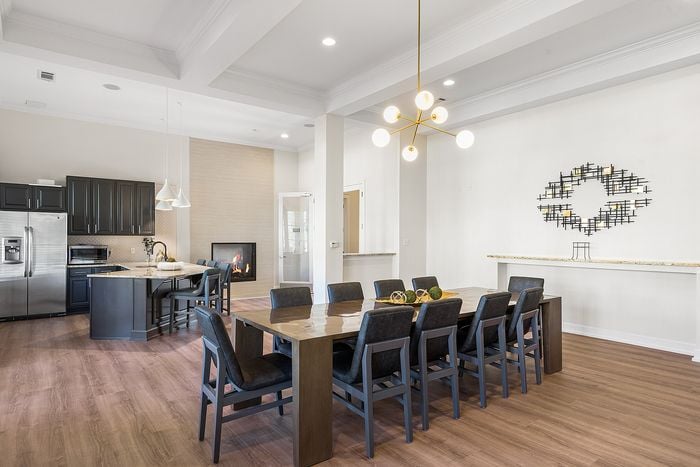 Luxurious open-concept kitchen and dining area with elegant lighting and a cozy fireplace, perfect for modern living.