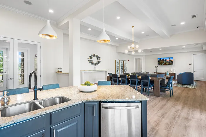 Elegant open-concept kitchen and living area with modern lighting, granite countertops, and chic dining space.
