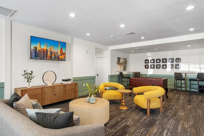 Chic modern living space featuring bold yellow armchairs, stylish decor, and a vibrant wall-mounted cityscape artwork.