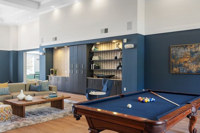 Elegant lounge area featuring a stylish sofa, modern decor, and a classic billiards table, perfect for relaxation and entertainment.