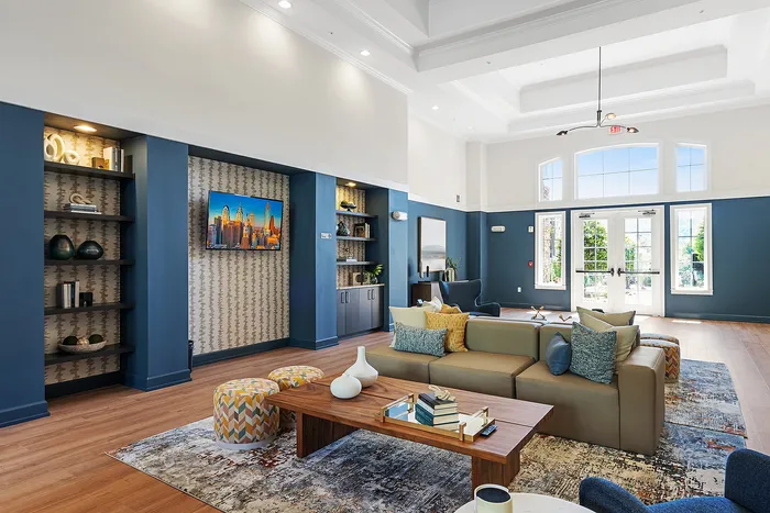 Inviting and modern living room with elegant decor, showcasing a cozy sectional sofa, vibrant cushions, and a sleek wooden coffee table.
