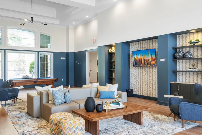 Inviting and stylish living room with expansive windows, a contemporary pool table, and cozy seating perfect for relaxation and entertainment.