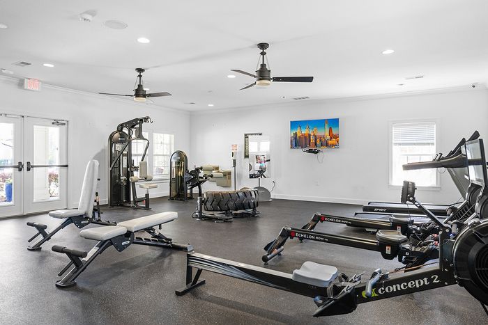 Modern fitness center equipped with state-of-the-art exercise machines, bright open space, and sleek design for a dynamic workout experience.