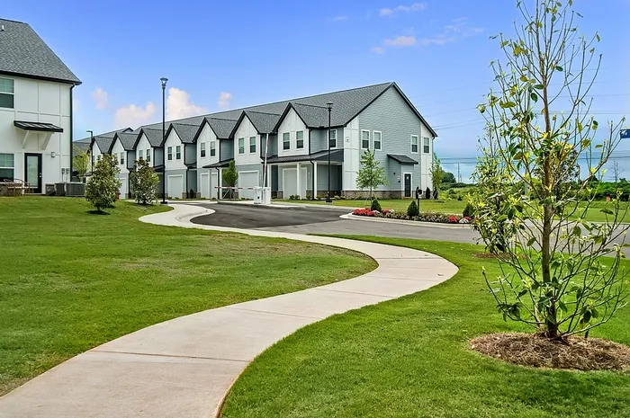 Charming residential community with modern townhouses and lush green landscaping, offering a serene environment and scenic views.