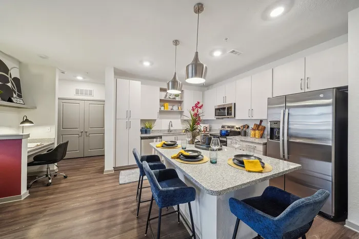 Modern kitchen design featuring sleek stainless steel appliances, granite countertops with elegant bar seating, and stylish pendant lighting.