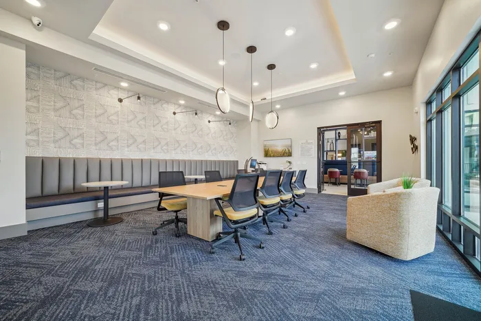 Modern conference room with elegant seating, contemporary lighting, and large windows for natural light.