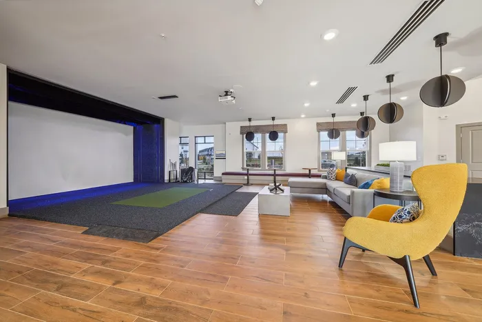Elegant open-concept living space featuring modern decor, hardwood floors, a comfortable lounge area, and a stylish mini-golf setup.