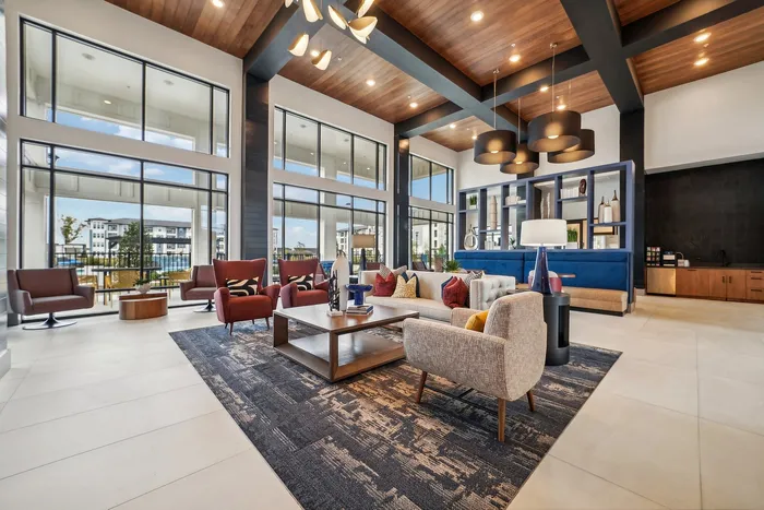 Sophisticated modern lounge featuring high ceilings, abundant natural light, and stylish seating with vibrant accents.