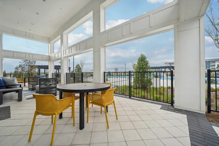 Chic outdoor patio with stylish seating and a scenic pool view, perfect for relaxation and entertaining.