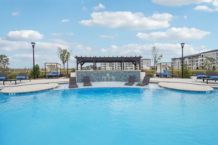 Inviting outdoor pool area with sleek lounge chairs and modern pergola, perfect for relaxation and enjoyment.