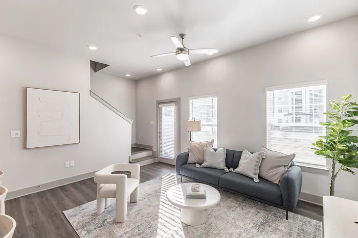 Chic and contemporary living room with plush seating, a stylish coffee table, and abundant natural light, offering modern elegance and comfort.