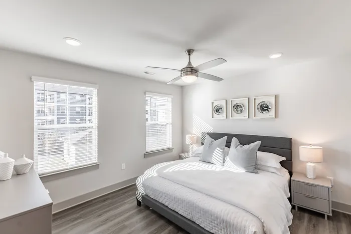Bright and inviting bedroom with modern furnishings, stylish decor, and ample natural light from large windows.
