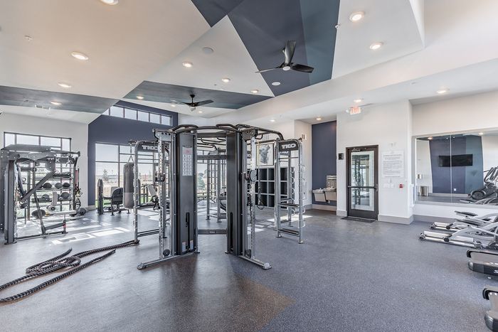 Modern gym facility with state-of-the-art equipment, stylish design, and abundant natural light for an energizing workout experience.