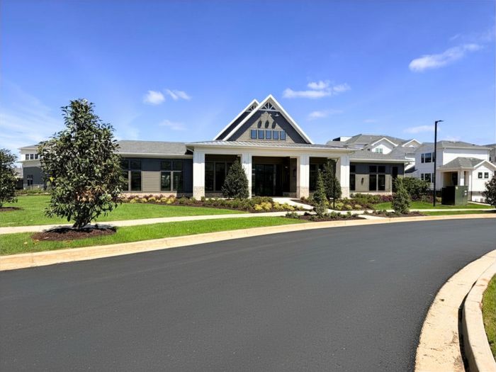 Charming residential building with modern design and lush landscaping, set against a clear blue sky.