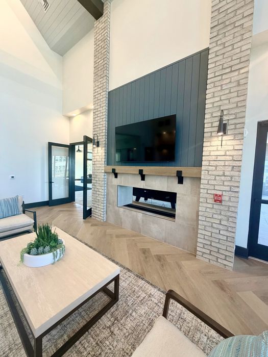 Chic living room with high ceilings, modern fireplace, and elegant decor. Perfect for relaxation and entertaining.