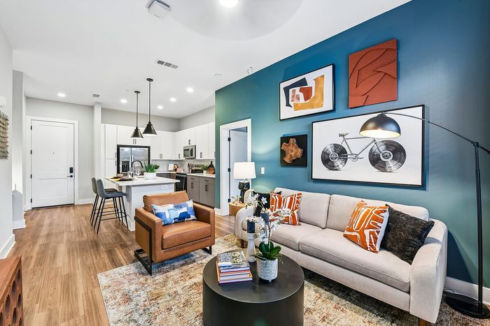 Chic open-concept living space with elegant art decor, modern kitchen, and cozy seating area.