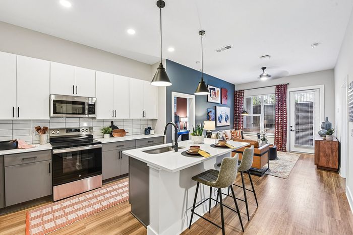 Modern open-concept kitchen and living area with a stylish island, sleek cabinetry, and inviting decor.