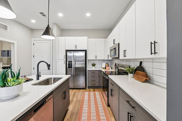 Modern kitchen with sleek cabinetry, stainless steel appliances, and stylish lighting, perfect for culinary enthusiasts.
