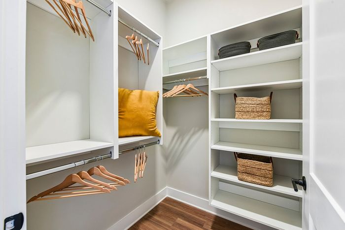 Spacious walk-in closet with elegant shelving, stylish hangers, and cozy decorative elements.
