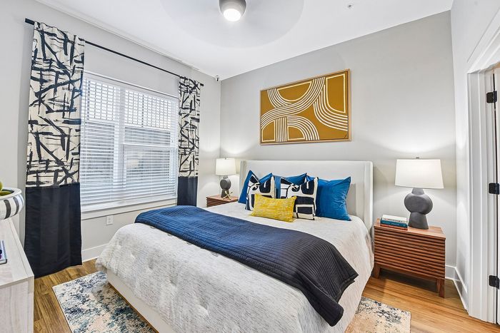Elegant bedroom featuring modern decor with abstract artwork, cozy bedding, and stylish lighting for a serene living space.