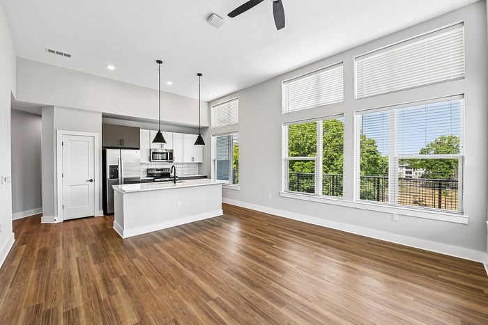 Bright, open-concept living area with sleek kitchen, modern appliances, and large windows offering beautiful views.