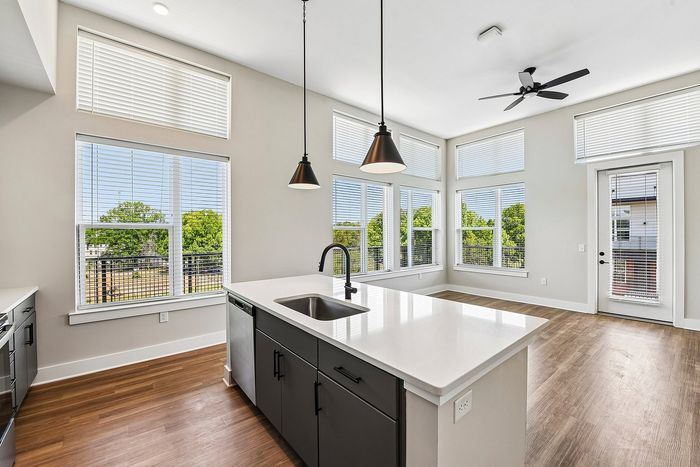 Bright and modern kitchen with sleek island and abundant natural light from large windows.
