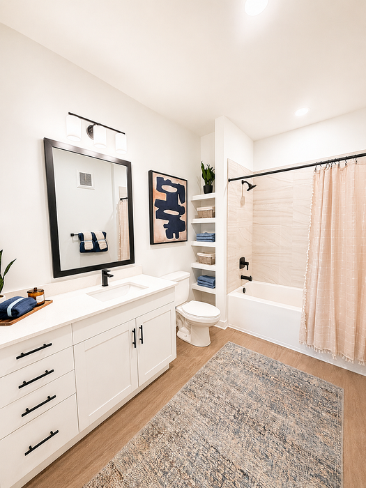 Elegant bathroom with modern fixtures, featuring a stylish vanity and a relaxing bathtub with a chic shower curtain.