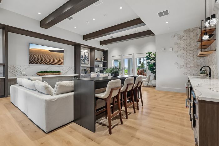 Modern open-concept living space with elegant kitchen, natural wood flooring, and stylish dining area perfect for entertaining.