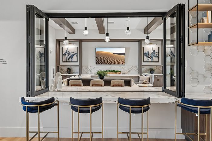 Sophisticated open living space with chic bar seating, modern decor, and ambient lighting, perfect for luxurious gatherings.