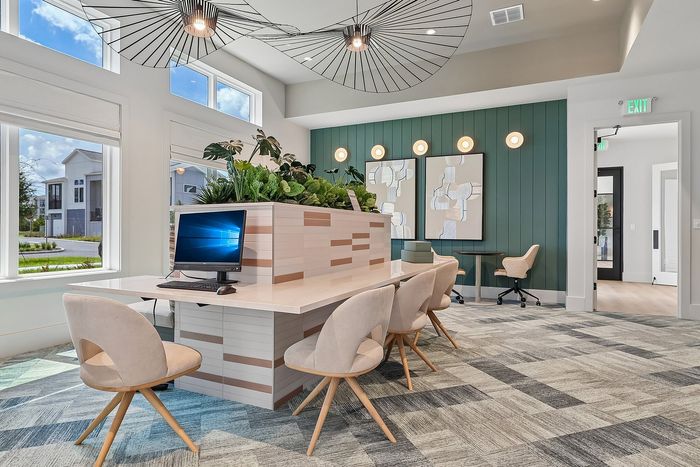 Modern co-working space with chic design, featuring stylish lighting, natural light, and contemporary art.