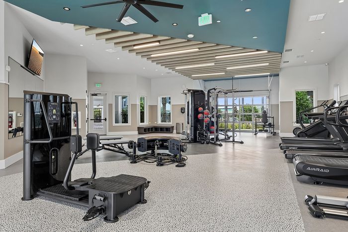 Modern fitness center with state-of-the-art equipment, bright lighting, and open design.