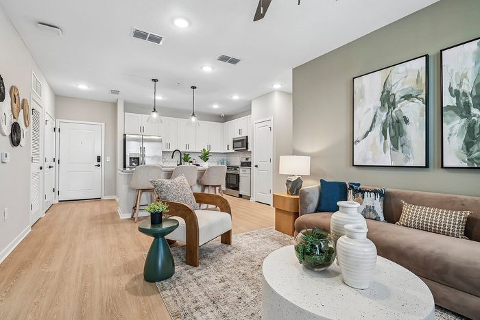 Elegant open-concept living area with stylish kitchen, cozy seating, and modern decor.