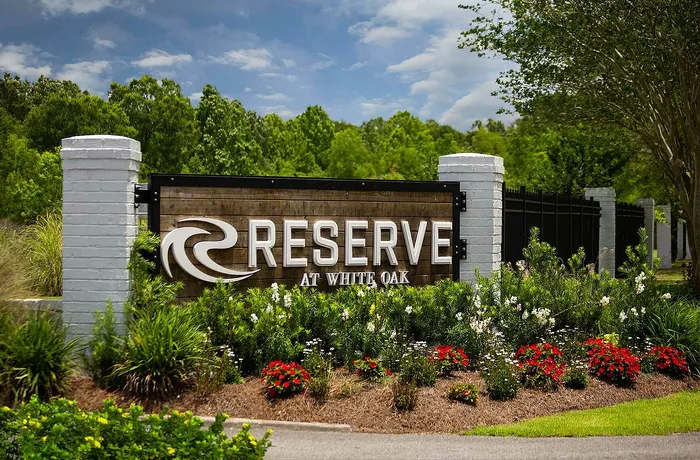 Inviting entrance sign for Reserve at White Oak, surrounded by vibrant landscaping and lush greenery.
