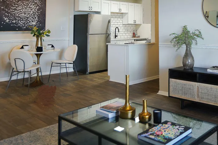 Elegant open-concept living space featuring a modern kitchen with stainless steel appliances, chic dining area, and stylishly decorated living room.