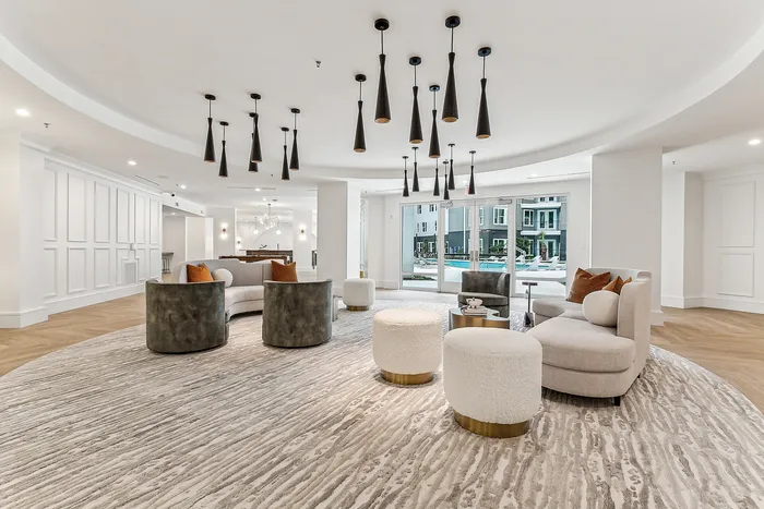 Luxurious contemporary lounge with modern lighting, plush seating, and pool view, ideal for relaxation and social gatherings.
