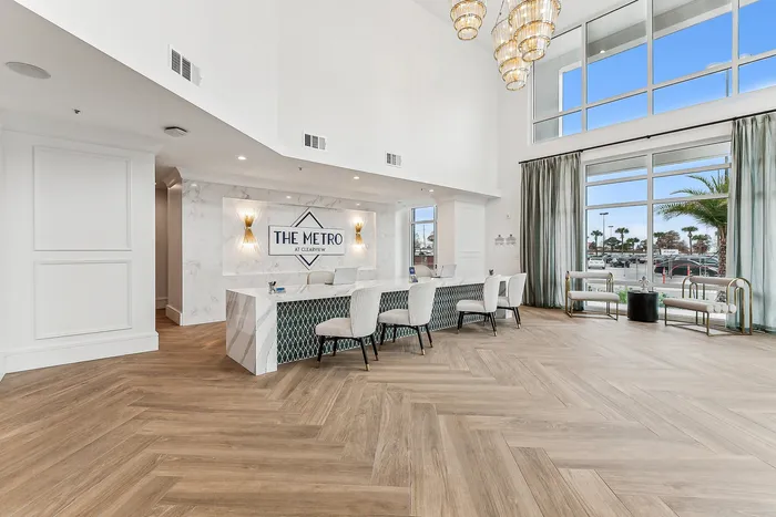 Elegant apartment lobby with a sleek reception desk, stylish seating, and large windows offering a bright and welcoming atmosphere.