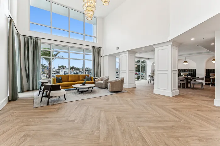 Elegant open-concept living area with floor-to-ceiling windows, stylish furnishings, and luxurious lighting, offering a spacious and inviting atmosphere.