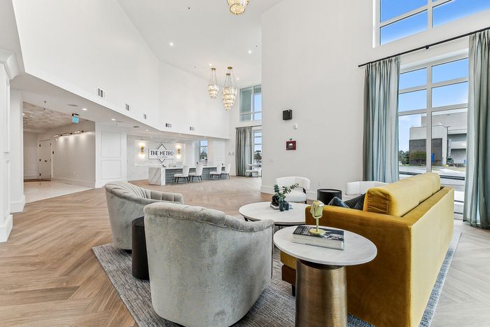 Elegant lobby interior with luxurious seating, grand lighting fixtures, and expansive windows at The Metro.