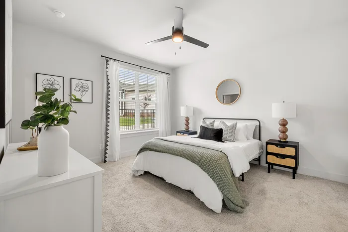 Elegant bedroom with plush carpeting, large window for natural light, stylish decor, and a cozy bed inviting relaxation.