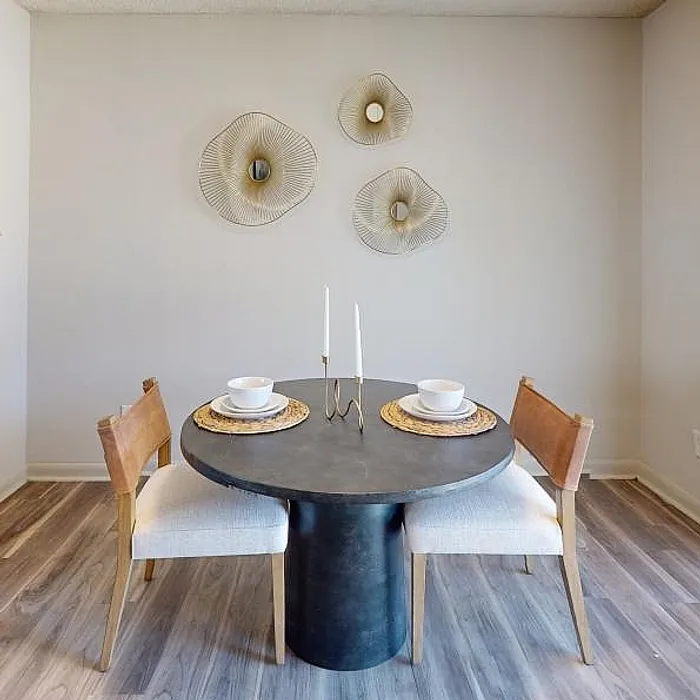 Chic dining nook with modern round table, elegant table settings, and contemporary wall decor, perfect for intimate meals.