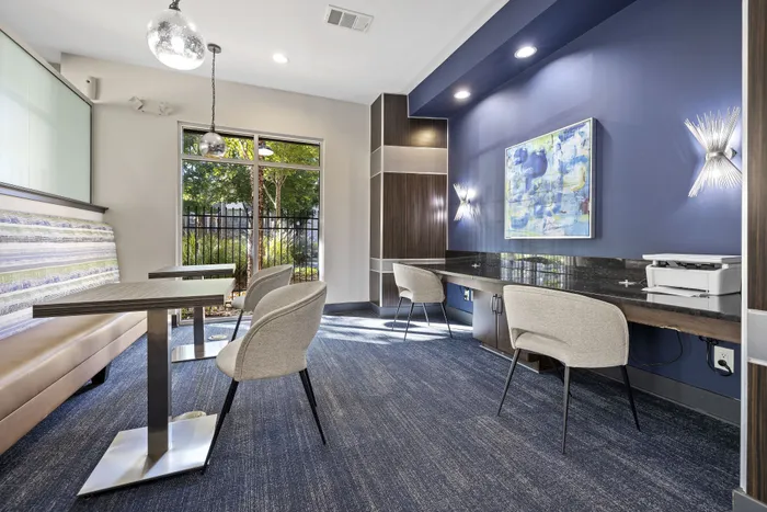 Modern and inviting workspace with stylish chairs, sleek tables, and vibrant wall art, offering an inspiring environment with natural light and elegant fixtures.